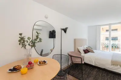 a bedroom with a large white bed with shoes on it at Sunshine Studios Portside Gothic in Barcelona
