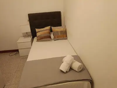 a bedroom with a bed with two towels on it at Habitación individual acogedora in Barcelona