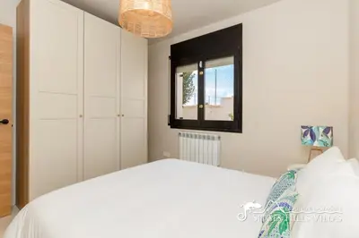 a bedroom with a large white bed and a mirror at Villa Caliza in Cunit with Private Pool and large garden - air conditioning in bedroom in Cunit