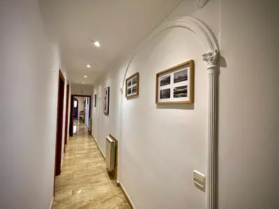 a hallway with white walls and a pillar with pictures at Precioso y espacioso piso in Arenys de Mar