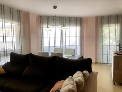 a living room with a couch and a dining room at Vivalidays - Estrella de Mar - Calella in Calella