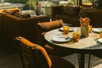 a table with plates and cups on a patio at The Social Hub Barcelona Poblenou Extended Stay in Barcelona