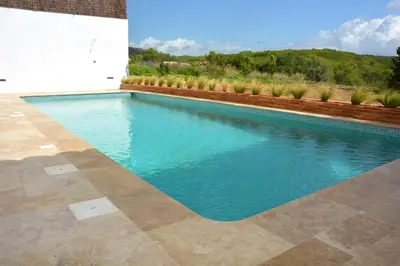 a swimming pool with blue water in a yard at Masia La Morera autenticidad renovada 100 porcien a 10 minutos de Sitges en coche 12 huespedes Piscina Aire Aconc 6 Suites Apertura 15 Julio 2025 in Viladellops