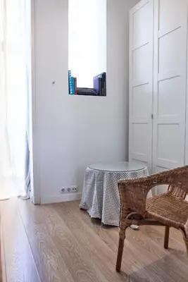 a white room with a table and a chair at Sunny apartment on the square in Barcelona