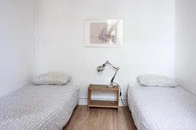 a bedroom with two beds and a lamp on a night stand at Sunny apartment on the square in Barcelona
