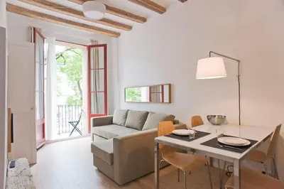 a living room with a couch and a table at Sunny apartment on the square in Barcelona