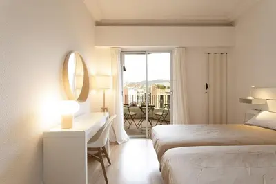 a bedroom with a bed and a desk with a mirror at Gran Vía Suites in Barcelona