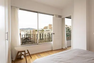 a bedroom with a bed and a large window at Gran Vía Suites in Barcelona