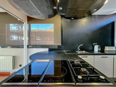 a kitchen with a stove top oven in a kitchen at Stylish villa with saltwater pool in Caldes d'Estrac