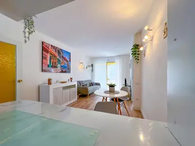 a living room with a table and a kitchen at Beachfront gateway in Pineda de Mar in Pineda de Mar