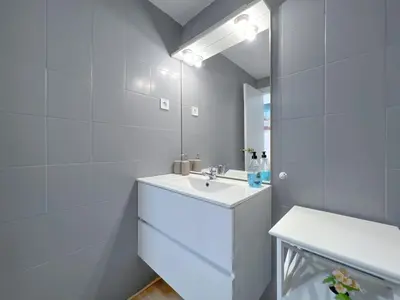 a white bathroom with a sink and a mirror at Beachfront gateway in Pineda de Mar in Pineda de Mar