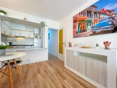 a kitchen with white cabinets and a table in a room at Beachfront gateway in Pineda de Mar in Pineda de Mar