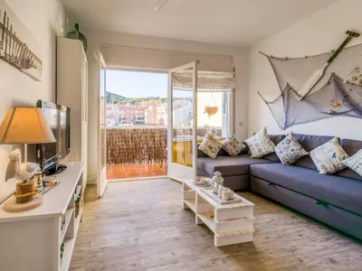 a living room with a blue couch and a tv at Apartment in Calella near the Beach in Calella