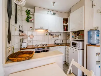 a kitchen with white cabinets and a wooden bowl on the counter at Apartment in Calella near the Beach in Calella