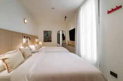 two large white beds in a hotel room at Design Suites by Olala Homes in Hospitalet de Llobregat