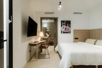 a hotel room with a bed and a desk at Design Suites by Olala Homes in Hospitalet de Llobregat