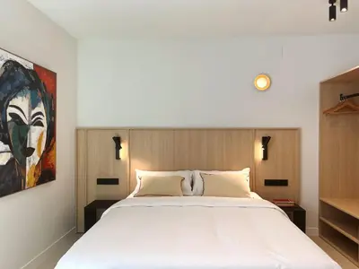 a bedroom with a bed and a painting on the wall at Design Suites by Olala Homes in Hospitalet de Llobregat