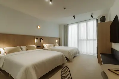 a hotel room with two beds and a television at Design Suites by Olala Homes in Hospitalet de Llobregat