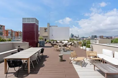 a rooftop patio with tables and chairs on a building at Monthly 32 Nights 1BR Pools Parking in Barcelona