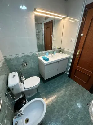 a bathroom with a toilet and a sink and a mirror at Habitaciones en la calle Valencia in Barcelona