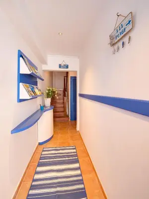 a hallway with blue and white walls and a striped rug at Blue Home in Sitges