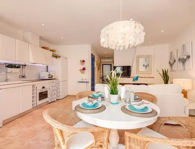a kitchen and living room with a white table and chairs at Blue Home in Sitges
