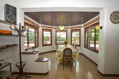 a dining room with a table and some windows at TURISME RURAL HORTA del PI in Cabrera de Mar