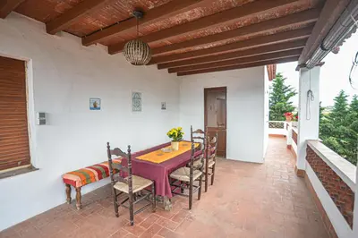 a patio with a table and chairs on a porch at TURISME RURAL HORTA del PI in Cabrera de Mar