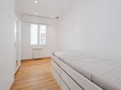 a living room with a fireplace and white walls at Large townhouse in St Cugat in Sant Cugat del Vallès