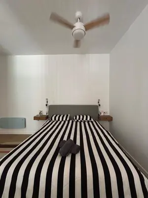 a bedroom with a bed with a black and white stripes at Son Roca Ribes Guest House in Sant Pere de Ribes