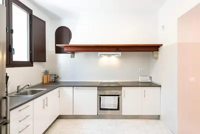 a kitchen with white cabinets and a sink at Unique 16th-Century Masia, Pool & Private Events in Barcelona