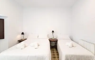 two beds in a room with white walls at Unique 16th-Century Masia, Pool & Private Events in Barcelona