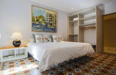 a bedroom with a large white bed and a painting at Provenza Flat in Barcelona
