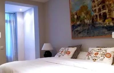 a bedroom with a bed and a painting on the wall at Provenza Flat in Barcelona