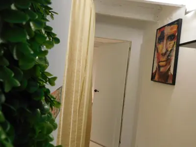 a hallway with a painting of a man on the wall at A pasos de la playa en Barcelona! in Barcelona
