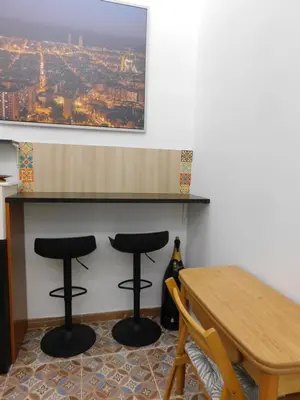 a dining room with two bar stools and a table at A pasos de la playa en Barcelona! in Barcelona