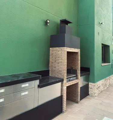 a kitchen with a brick oven in a green wall at El Desmai in San Pol de Mar