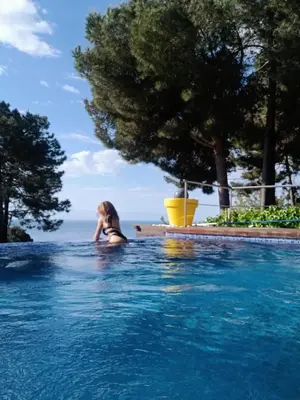a woman sitting in a swimming pool at El Desmai in San Pol de Mar