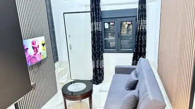 a living room with a couch and a tv at Casa hamburg BCN in Badalona