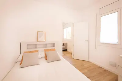 a white bedroom with a bed with two pillows at Lovely apartment with 3 bedroom in Cornellà de Llobregat