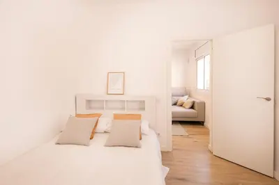 a white bedroom with a bed and a couch at Lovely apartment with 3 bedroom in Cornellà de Llobregat