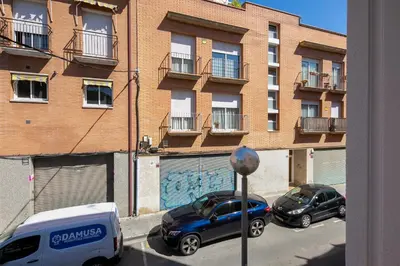 two cars parked on a street in front of a building at Lovely apartment with 3 bedroom in Cornellà de Llobregat