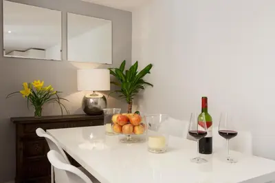 a white table with a bowl of fruit and wine glasses at Aspasios Charming Flats in Barcelona