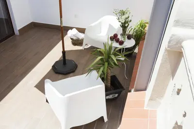 a room with two white chairs and plants at Aspasios Charming Flats in Barcelona