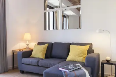 a living room with a blue couch and a mirror at Aspasios Charming Flats in Barcelona