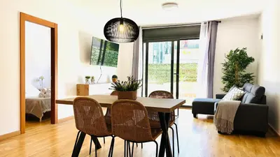 a living room with a dining room table and chairs at Bajos con jardín in Terrassa