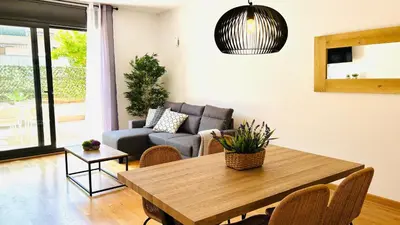 a living room with a table and a couch at Bajos con jardín in Terrassa