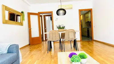 a living room with a table and chairs at Bajos con jardín in Terrassa