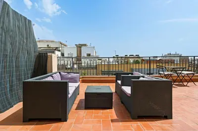 a patio with two chairs and a table on a roof at Flateli Calàbria in Barcelona