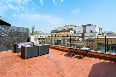 a patio with furniture and a table on a roof at Flateli Calàbria in Barcelona
